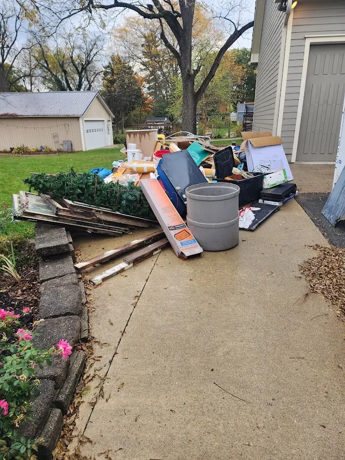 Dumpster being loaded with debris for 12 Yard Dumpster Rental in Forest City